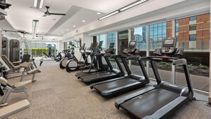 A modern gym with treadmills, elliptical machines, and weightlifting equipment. - Austin Beautiful Studio Apartment (Austin)