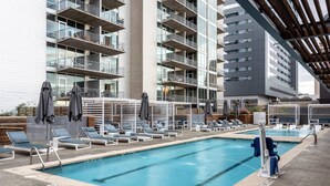 A modern hotel pool area with multiple pools, lounge chairs, and umbrellas. - Austin Unique 1BD 1BA 2nd Street District Apartment (Austin)