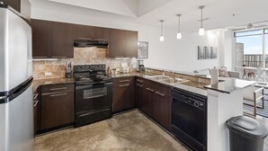 Una cocina moderna con armarios de madera oscura, electrodomésticos de acero inoxidable y un ventanal con vistas a la ciudad.