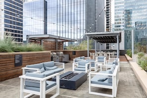 An outdoor patio with modern seating, a barbecue area, and a pergola. - Austin Irresistible 1BD 1BA 2nd Street District Apartment (Austin)