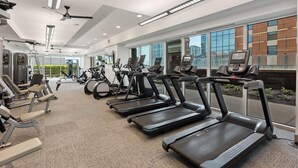 Ein modernes Fitnessstudio mit Laufbändern, Ergometer und Krafttrainingsgeräten.