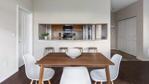 Een moderne keuken met houten kastjes, roestvrijstalen apparatuur en een centraal kookeiland met barkrukken.
