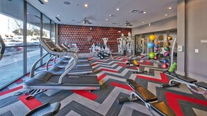 A gym with treadmills, elliptical machines, and free weights. - Dallas Beautiful 1BD 1BA Downtown Apartment (Dallas)