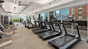 A modern gym with treadmills, exercise bikes, and weight machines. - Austin Awesome Studio Apartment (Austin)