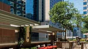 A rooftop pool with red and white seating, surrounded by modern buildings. - Austin Awesome Studio Apartment (Austin)