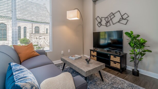 A modern living room with a sofa, coffee table, TV, and decorative wall art. - Des Moines Heavenly 1BD 1BA Downtown Apartment (Des Moines)