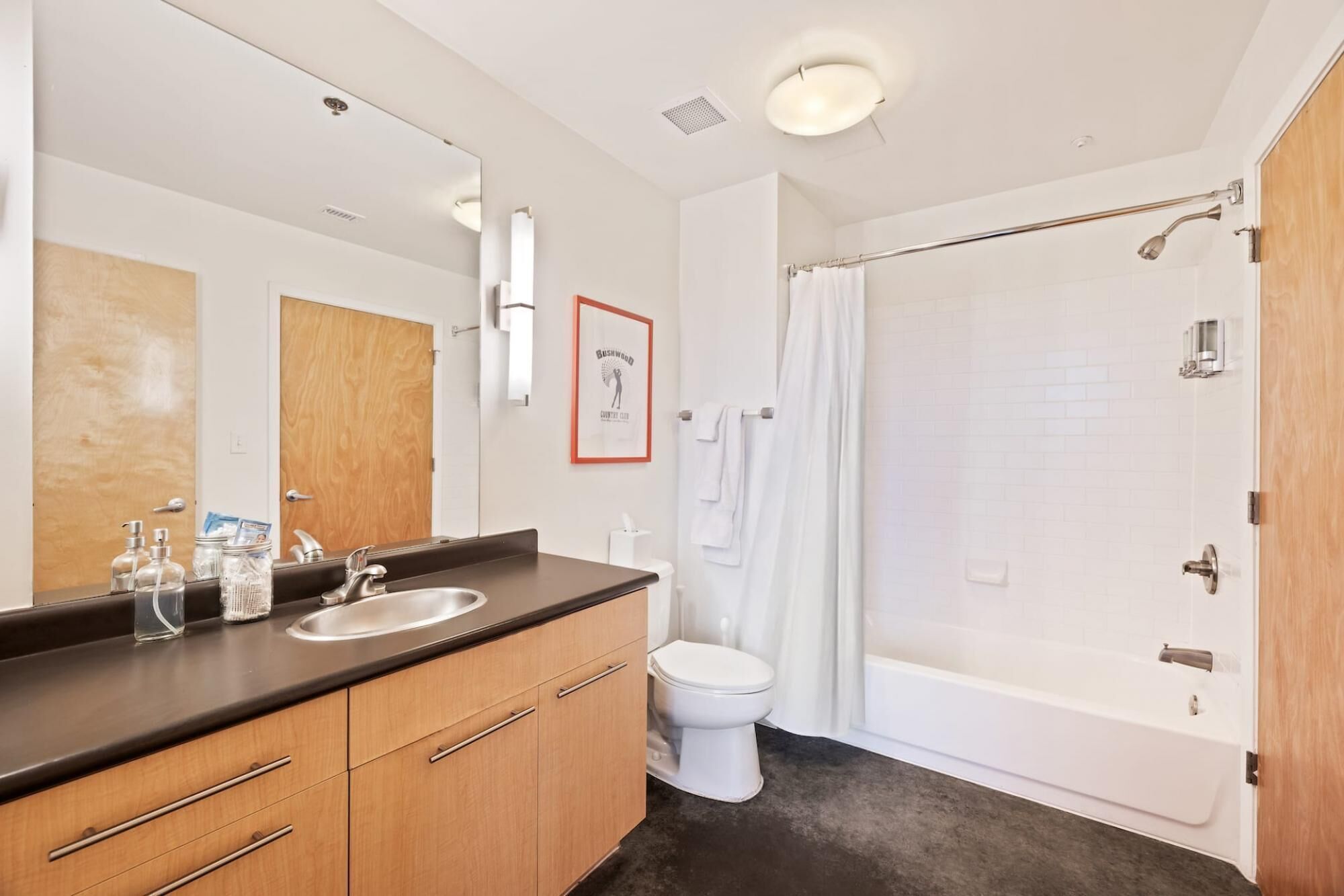 A modern bathroom with a double sink vanity, a toilet, and a walk-in shower.