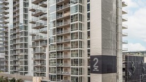 A modern high-rise building with multiple balconies and large windows.