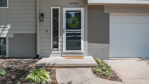 Une maison avec le numéro 12950 sur la porte, un porche à l’avant et un mur en briques.
