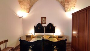 A bedroom with a double bed, two bedside tables, a wooden wardrobe, and a chair. - Casa Marieli - A 50 m dal Mare con Spazio Esterno (Gagliano del Capo)