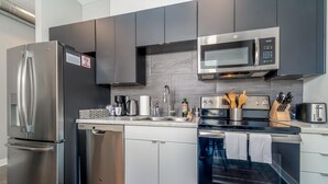 Une cuisine moderne équipée d’appareils électroménagers en acier inoxydable, d’un four à micro-ondes et d’un lave-vaisselle.