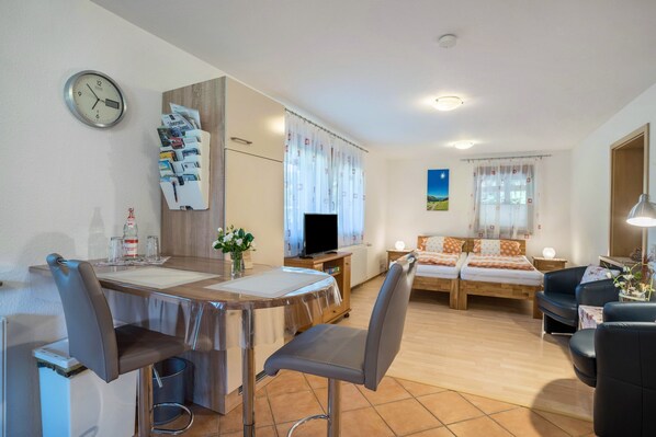 Une chambre moderne équipée d’une table à manger, de chaises, d’un téléviseur, d’un lit et d’un canapé.