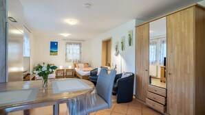 Een moderne kamer met een eettafel, een bank, een bed en een kledingkast.