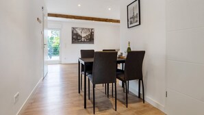 Un coin repas avec une table et des chaises, un tableau encadré au mur et une poutre en bois au plafond.