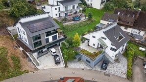 Ein moderner Wohnbereich mit Einfamilienhäusern, Solaranlagen und einem Swimmingpool.