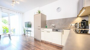 Eine moderne Küche mit Spülmaschine, Kaffeemaschine und einer Uhr an der Wand.