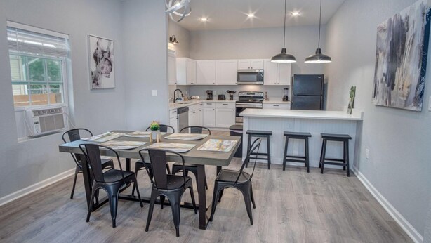 A modern kitchen with white cabinets, a central island, and pendant lighting.