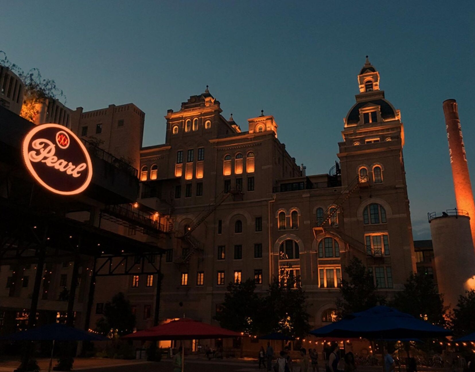 A historic building with illuminated windows and a prominent sign for 'Pearl'.
