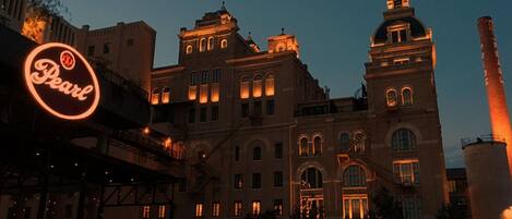A historic building with illuminated windows and a prominent sign for 'Pearl'.