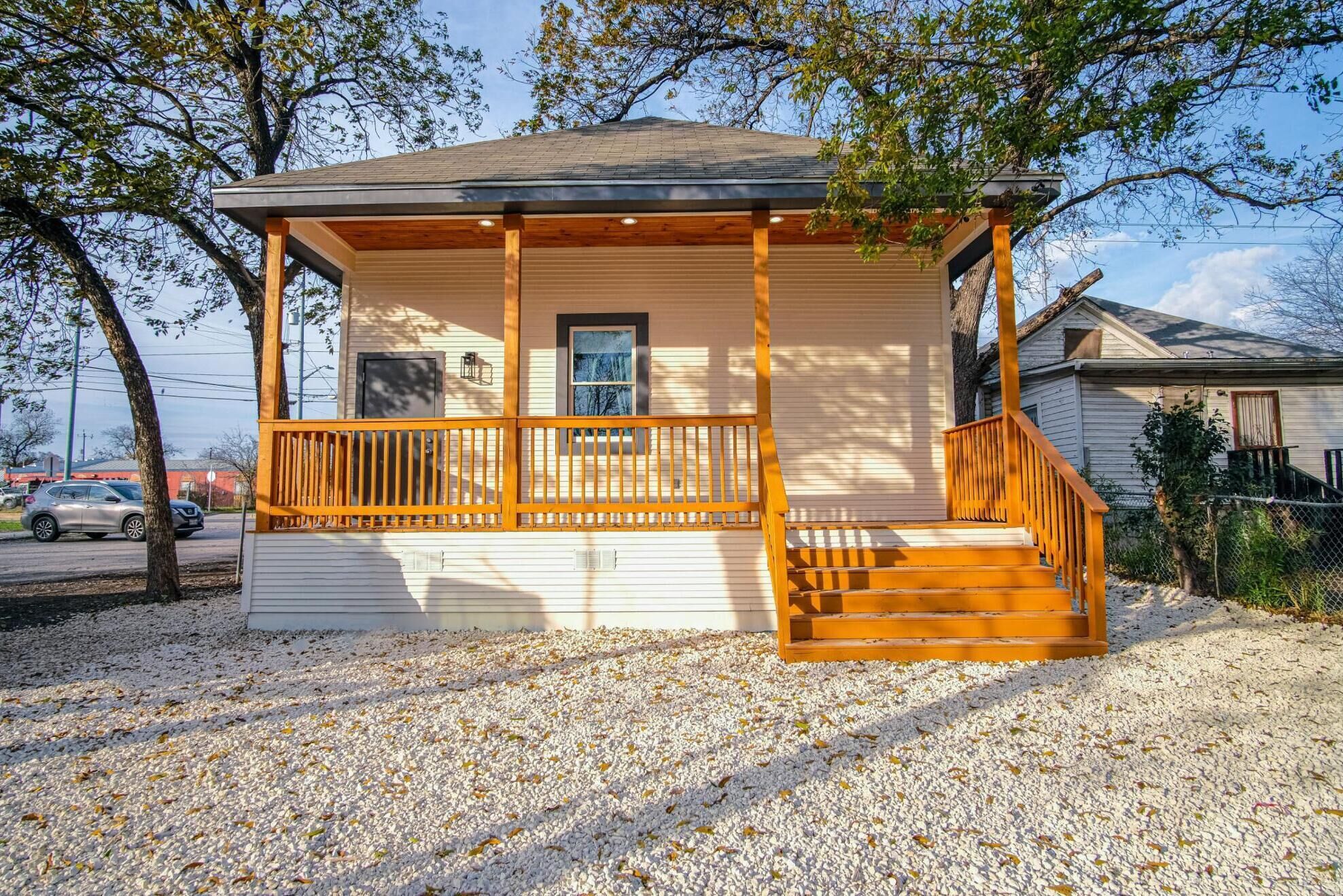 A single-story house with a wooden porch and a small attached garage.