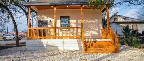A single-story house with a wooden porch and a small attached garage.