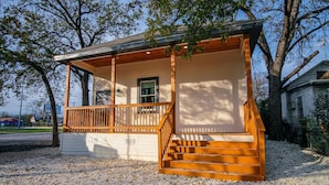A single-story wooden house with a porch and a set of stairs leading to a front door. - Magnificent 4BR Near Famous Riverwalk and Downtown (San Antonio)