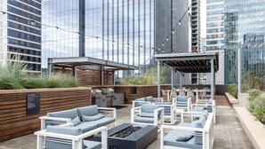An outdoor patio with modern seating, a barbecue area, and a pergola. - Austin Remarkable 1BD 1BA 2nd Street District Apartment (Austin)