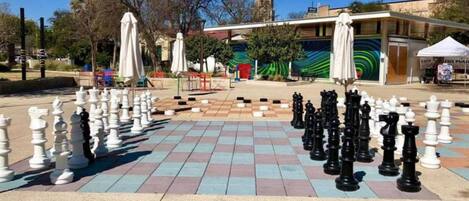 A chessboard set up outdoors with a building in the background.