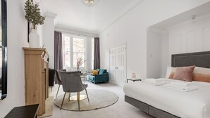 Une chambre moderne avec un grand lit, un bureau, une chaise et un canapé.