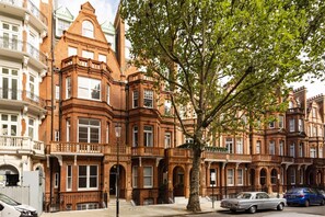 A row of Victorian-style brick buildings with large windows and ornate detailing.