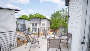 A patio area with outdoor furniture and a view of neighboring buildings. - Brand NEW 4 Stylish 3BR Near Exciting Downtown (San Antonio)