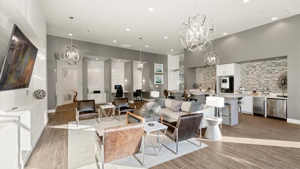 Un salon moderne avec un canapé, des fauteuils et un coin repas.