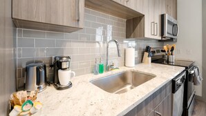 Eine moderne Küche mit Granit-Arbeitsplatten, Edelstahlgeräten und Holzschränken.