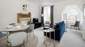 A modern living room with a fireplace, a dining area, and a sofa. - The Knightsbridge Suite Next to Sloane Square (London)