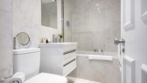 Une salle de bain moderne équipée de toilettes, d’un lavabo et d’une douche.