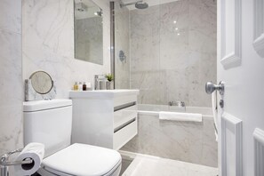 A modern bathroom with a toilet, sink, and shower.