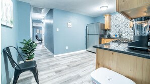 A modern kitchen with a double refrigerator, a built-in oven, and a black countertop. - Fascinating 2BR 1BA Near Festive DT and Riverwalk (San Antonio)
