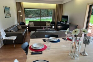 Un salon moderne avec un canapé, une table à manger et un téléviseur.