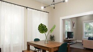 A dining area with a wooden table, two chairs, a bench, and a plant. - Amazing Fully Fenced Home Only 1 7 mi to Downtown (San Antonio)