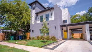 A modern two-story house with a garage, a well-maintained lawn, and a clear sky. - Gorgeous 3 BR 2 BA Near Amazing Downtown (San Antonio)