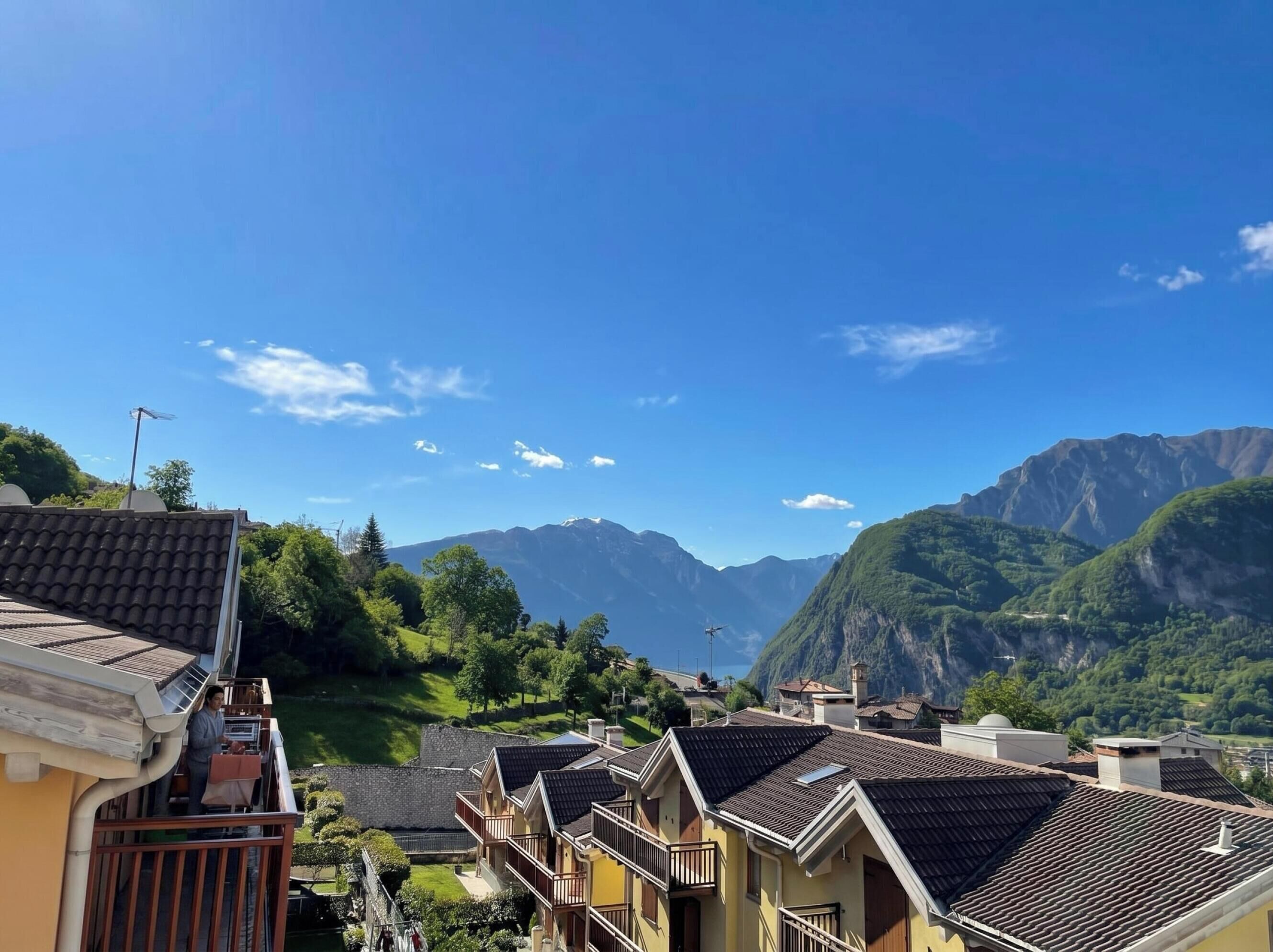 Un quartier résidentiel avec des maisons, un balcon et un paysage montagneux en arrière-plan.
