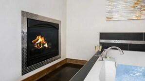 Une salle de bain avec une cheminée, un lavabo et un mur décoratif.