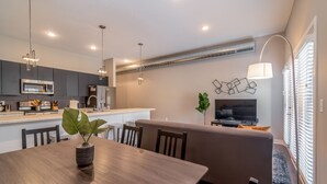A modern kitchen with dark cabinets, stainless steel appliances, and pendant lighting. - Des Moines Beautiful 2BD 2BA Downtown Apartment (Des Moines)