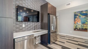 A modern kitchen with a stainless steel refrigerator, a built-in dishwasher, and a large window above the sink. - Des Moines Beautiful 2BD 2BA Downtown Apartment (Des Moines)