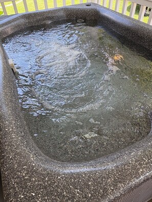 A hot tub with a textured stone exterior and a metal drain. - Stay In Ohiopyle & Relax in Town Near The GAP Trail, Hot Tub (Ohiopyle)