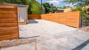 A fenced backyard with a gravel area and a wooden shed. - Cozy and Lovely 2BR 1BA Apt B Near Lively Downtown (San Antonio)