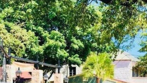 A courtyard with a blue pergola, a sign with the number 325, and lush green plants. - Fascinating 1BR 1 BA Near Festive DT and Riverwalk (San Antonio)