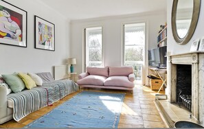Relax in this stylish living room with a plush sofa, striped throw, and cozy fireplace.