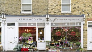 A storefront with a sign reading "Karen Woolven Flowers at Greenwich." - Greenwich Perfection (London)