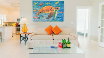 Una sala de estar con sofá, una mesa de centro y una obra de arte de una tortuga marina.